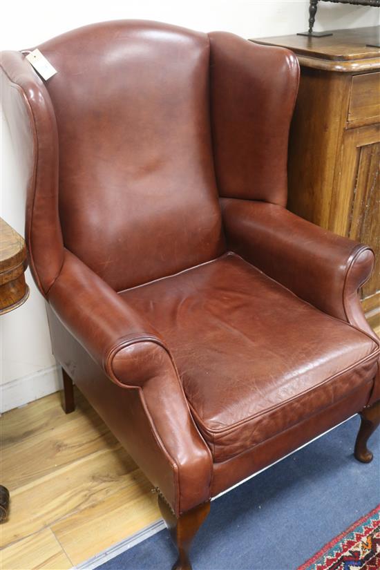 A brown leather wingback armchair